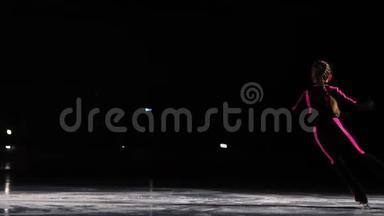 一个专业的滑冰运动员在冰上<strong>进行</strong>空中旋转的滑冰跳跃。 花样滑冰的三个轴